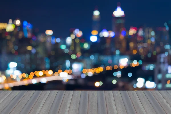 Apertura de piso de madera, luces borrosas vista nocturna, centro de la ciudad, fondo abstracto — Foto de Stock