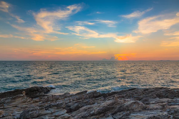 Sunset over rocky beach with colourful sky — Stock Photo, Image