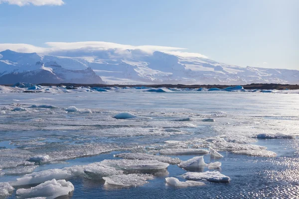 Hermoso derretimiento de hielo en la laguna con fondo de montaña — Foto de Stock