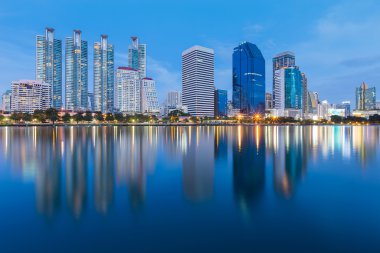 Alacakaranlık şehir ofis kule ile tam su yansımalar