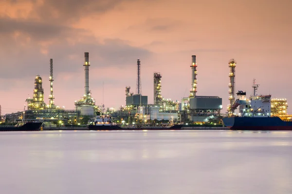 Нефтеперерабатывающий завод на берегу реки с сумеречным небом — стоковое фото