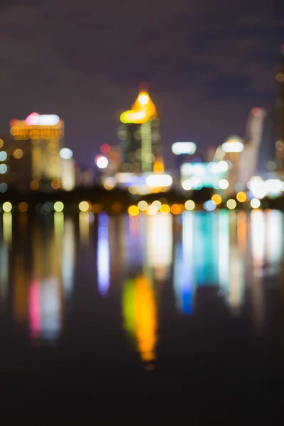 Vatten reflektion av suddiga staden ljus på natten — Stockfoto