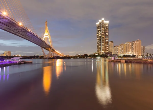Crepúsculo da ponte de suspensão e apartamento com vista para a frente da água — Fotografia de Stock