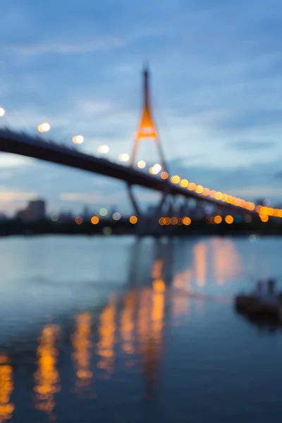 Abstract blurred bokeh light, suspension bridge with water reflection — Stock Photo, Image