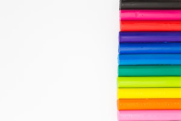 Colourful plasticine clay on right side of white background — Stock Photo, Image