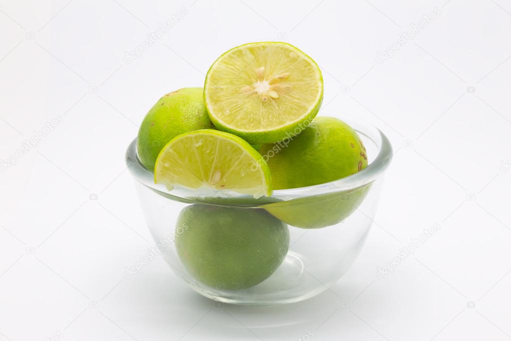 Glass bowl of Limes and slice on white background
