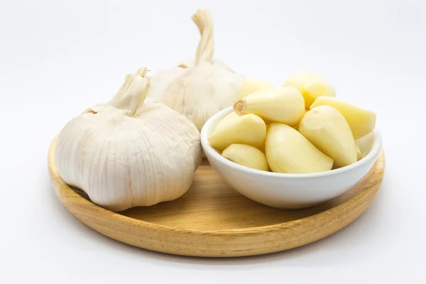 Fresh garlic on wooden plate on white — Stock Photo, Image