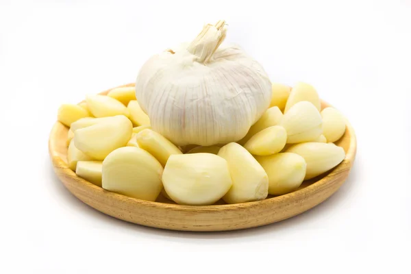 Fresh raw root garlic on wooden plate — Stock Photo, Image