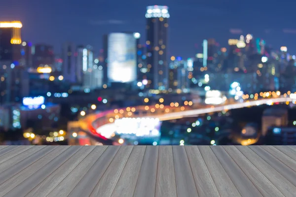 Wooden floor roof top view with blurred city bokeh lights during twilight — Stock Image Wooden floor roof top view with blurred city bokeh lights during twilight Stock Photo