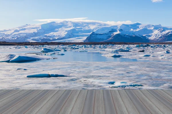 Pavimento in legno aperto, ghiacciaio Jokulsarlon con montagna innevata — Foto Stock