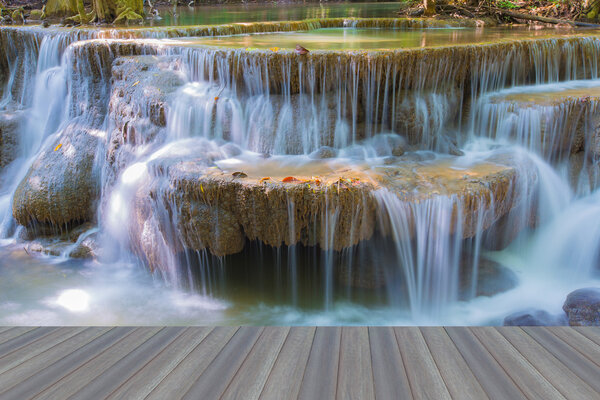 Open wooden floor, close up of beautiful deep forest water fall on national park
