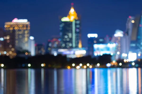 Astratto offuscata bokeh città centro vista notturna con riflesso dell'acqua — Foto Stock