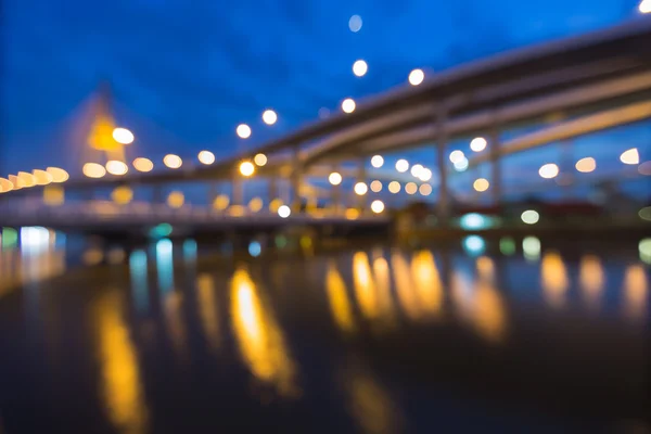 Blurred bokeh city lights highway with suspension bridge background during twilight — Stock Photo, Image