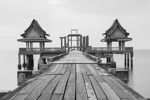 Preto e branco, ponte de madeira que conduz ao edifício inacabado do temple no mar — Fotografia de Stock