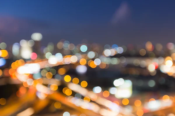 Vista aérea cidade centro da estrada intersecção durante o crepúsculo, fundo de luz bokeh borrada — Fotografia de Stock