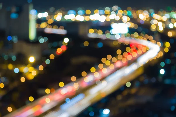 Suddig bokeh ljus city downtown highway böjd på natten — Stockfoto