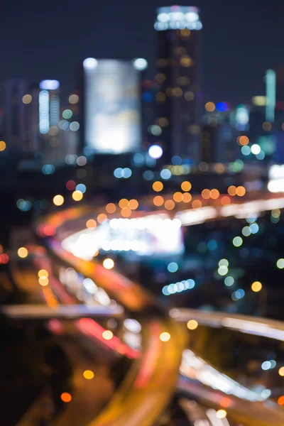 Abstrato embaçado bokeh luzes rodovia cruzamento com a cidade centro da noite — Fotografia de Stock