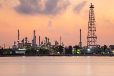 Benzin kimyasal rafineri sanayi tesisi waterfront, gündoğumu sırasında dramatik gökyüzü