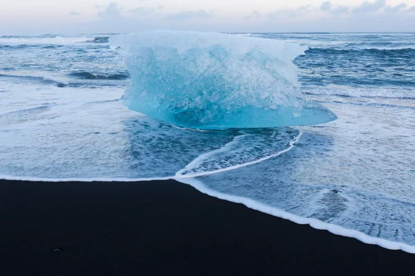 在火山黑沙海滩上破冰 — 图库照片