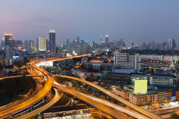Bangkok highway interchanged with city downtown background during twilight