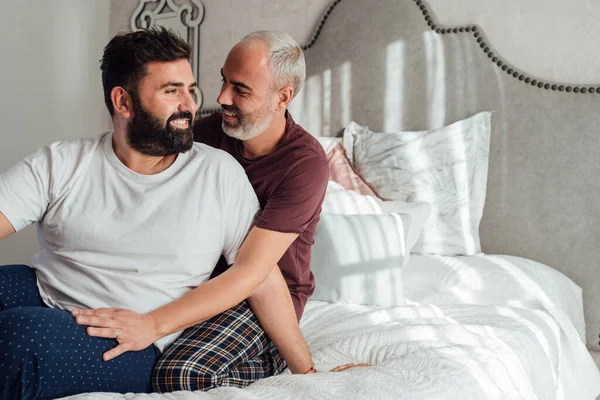 Gay couple hugging in bed Concept of home