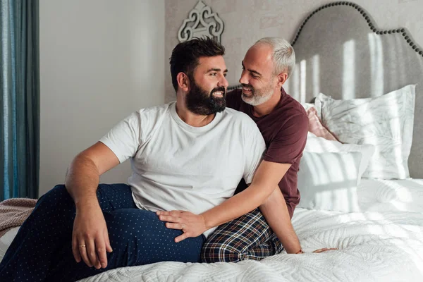 Evde aileleriyle iyi vakit geçirirken yatakta konuşan ve flört eden eşcinsel çift. Sarılırlar ve birbirlerinin kulaklarına güzel şeyler söylerler..