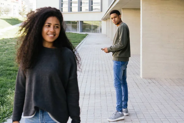 Afro homem andando e olhando com espanto para outra menina sedutora — Fotografia de Stock