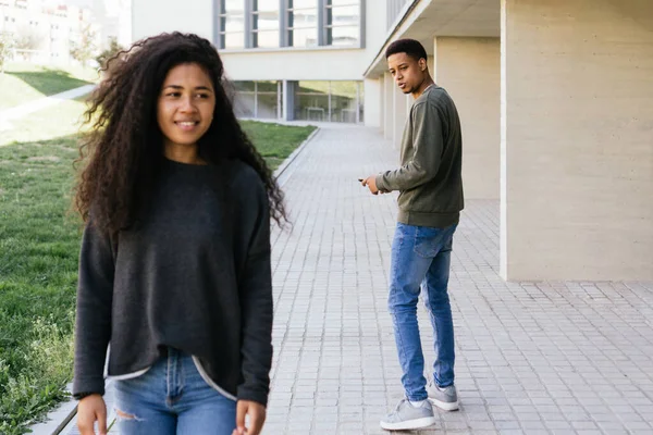 Afro Latino homem olha com admiração e amor para uma menina afro-americana andando rua abaixo. — Fotografia de Stock