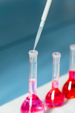 Fen laboratuarı test tüpü ve damla ve kırmızı sıvı ile pipet, yakın çekim laboratuvar ekipmanı, dikey fotoğraf, kopyalama alanı