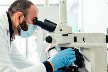 Laboratuvarda mikroskop kullanan bir bilim adamı. Sağlık teknolojisi ve tıbbi araştırma ve geliştirme kavramı.