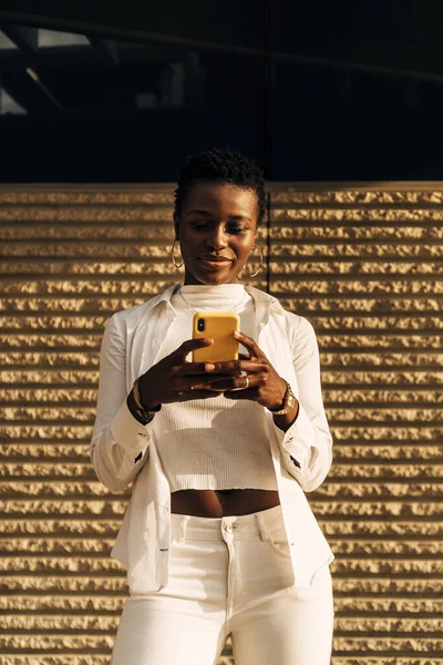 Retrato ao ar livre de uma jovem negra afro-americana usando um telefone celular. — Fotografia de Stock