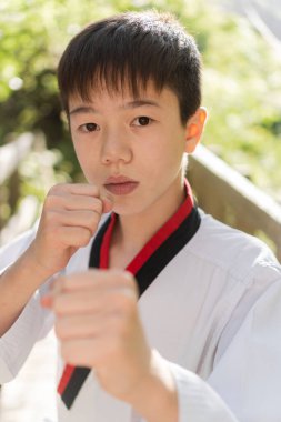Karateka 'lı çocuk dövüş sanatları eğitimi sırasında saldırı pozu veriyor..