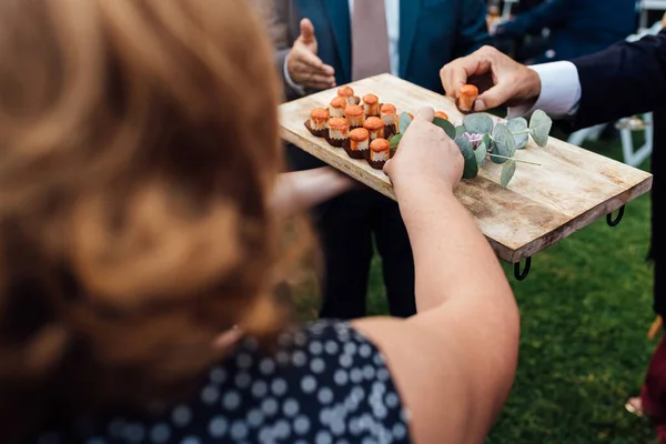 Gente tomando bocadillos del camarero durante una fiesta. — Foto de Stock