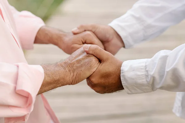 Romantik, orta yaşlı, eşcinsel bir çiftin çıkma sırasında nazikçe el ele tutuşması..