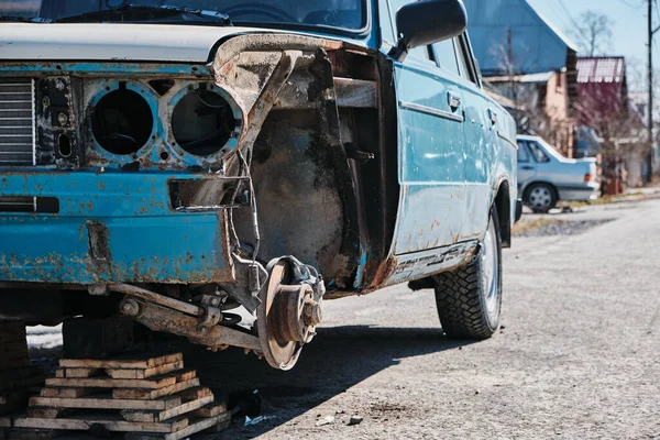 Old broken blue car with rust, brake disc with rust