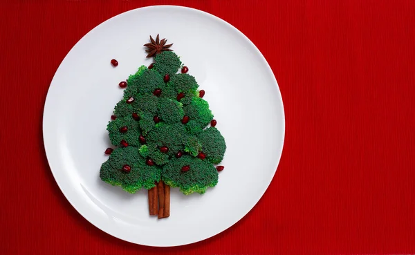 White plate on red table, broccoli tree, Christmas background, horizonta, no people, — Stock Photo, Image