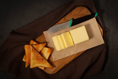 Bir parça tereyağı, dilimlenmiş, ekmek dilimlenmiş, siyah arka planda, insan yok, yatay, üst manzara,