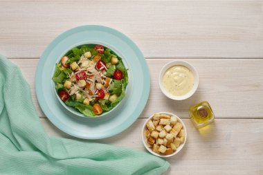  Beyaz ahşap bir masada çivili Sezar salatası, üst manzara, insan yok.,