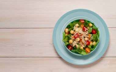  Beyaz ahşap bir masada çivili Sezar salatası, üst manzara, insan yok.,