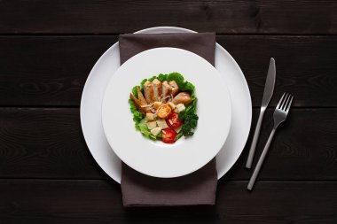  Sezar salatası ve chiken, siyah ahşap bir masada, üst manzara, insan yok.,