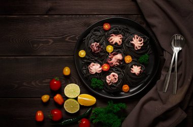 Siyah makarna, bebek ahtapot, tabak, siyah ahşap arka planda, üst manzara, insan yok., 