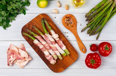 Yeşil kuşkonmaz, jambonlu, çiğ, baharatlı, beyaz bir masada, üst görünümde, yatay, insan yok.,