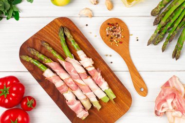 Yeşil kuşkonmaz, jambonlu, çiğ, baharatlı, beyaz bir masada, üst görünümde, yatay, insan yok.,