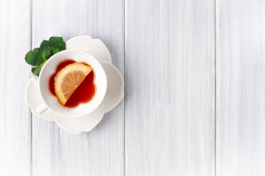 Beyaz bardakta, çay, nane ve limon, beyaz ahşap bir masanın üstünde, yatay, insan yok.,