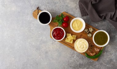 Set, soslar, ketçap, mayonez, peynir, soya, yeşil, kesme tahtasının üzerinde, malzemelerle, gri bir masada, üst manzara, insan yok.,
