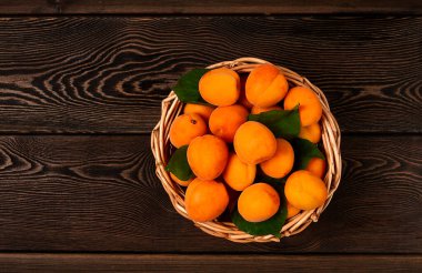 Taze kayısı, yapraklı, sepetli, ahşap bir masada, yatay, insan yok.,