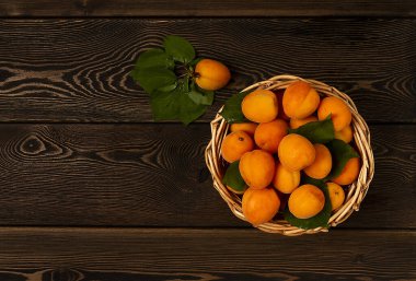 Taze kayısı, yapraklı, sepetli, ahşap bir masada, yatay, insan yok.,