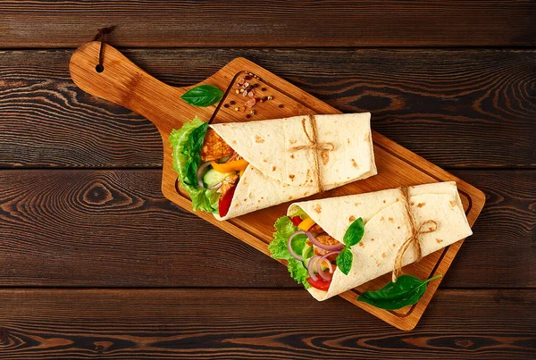 Tortilla avvolge, pollo messicano alla griglia con verdure, burrito, su un tavolo di legno, senza persone, — Foto Stock