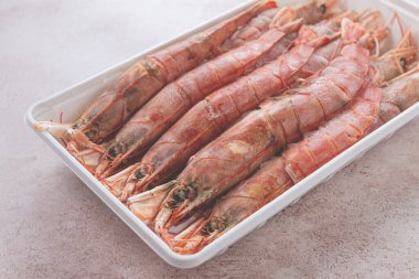 Taze donmuş Arjantin karidesi, bir konteynırda serilmiş, üst manzara, insan yok.,