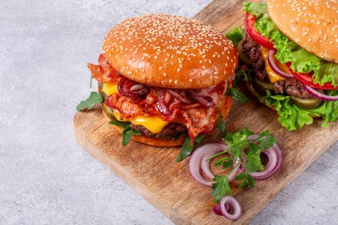 İki köfteli burger, kızarmış pastırma, çedar peyniri, domates, ev yapımı, insan yok.,